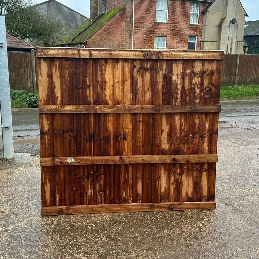 A closeboard fence panel standing upright on concrete path, showing the rear.